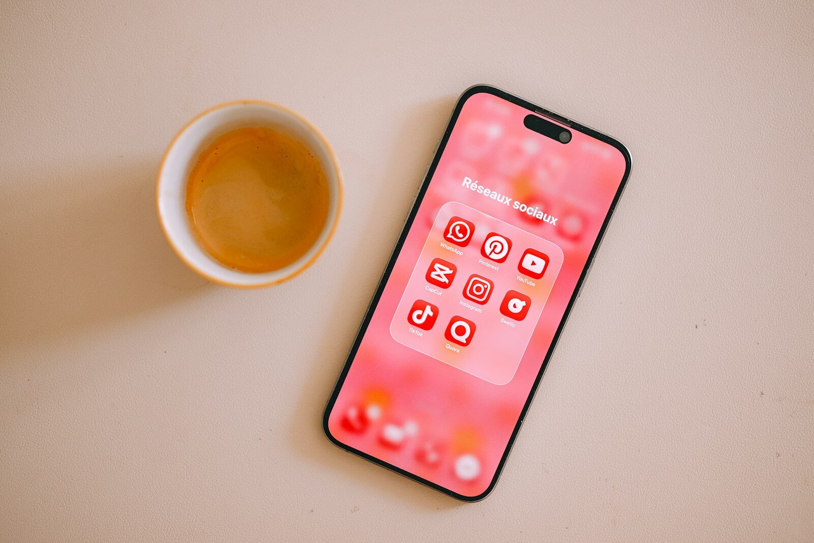 Coffee cup and smartphone with pink app icons