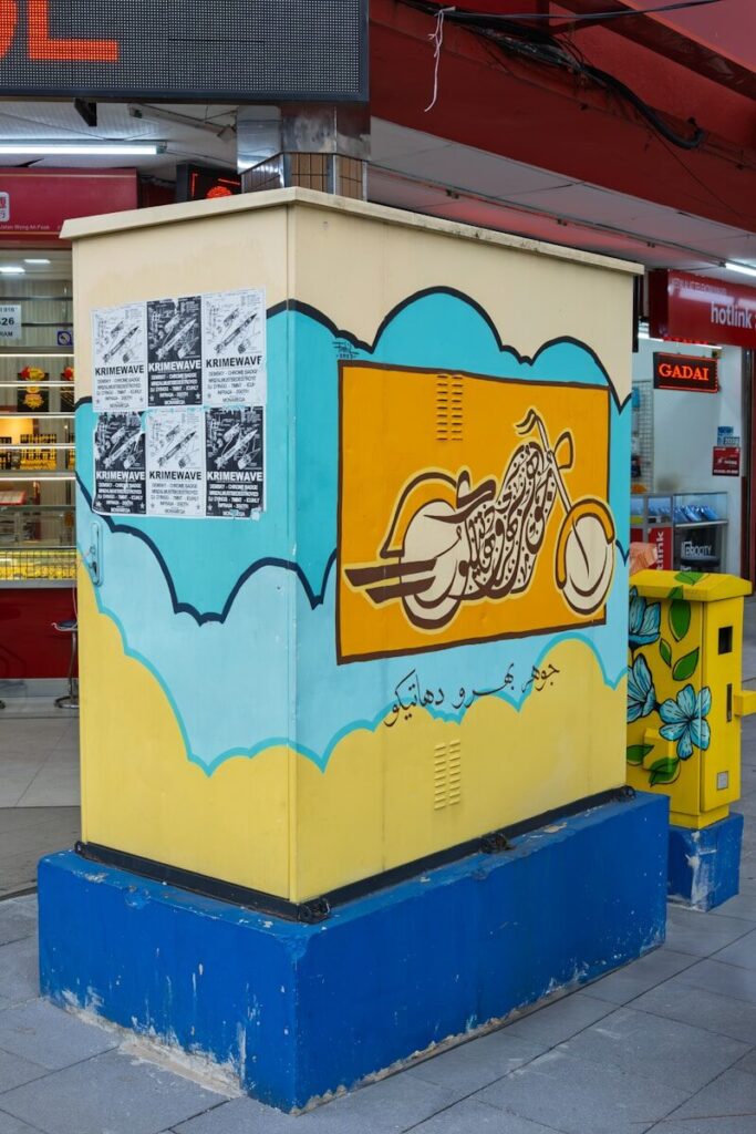 Utility box painted with a motorcycle and calligraphy