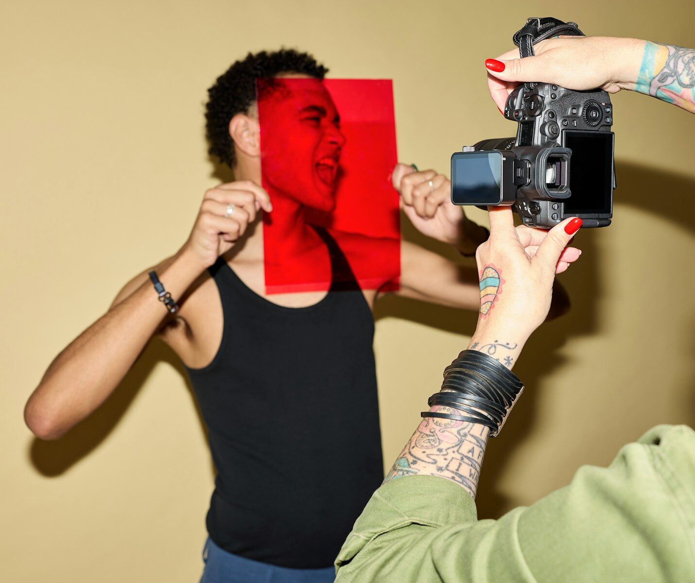 Man's face through red filter, being photographed by camera