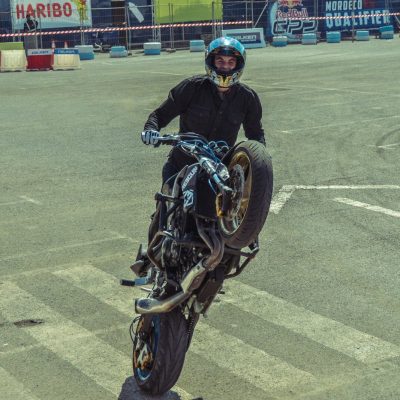 man doing wheelie on black street bike