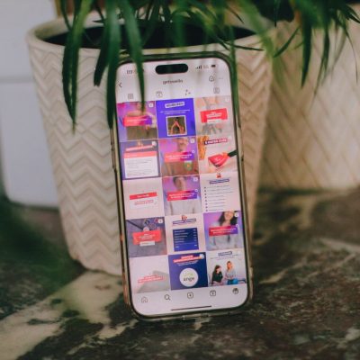 a cell phone sitting on top of a table next to a potted plant